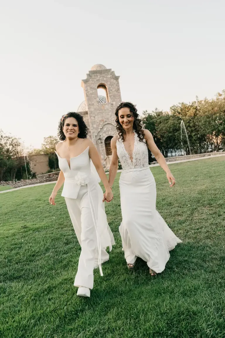 Dos novias caminando hacia la cámara en la hora dorada