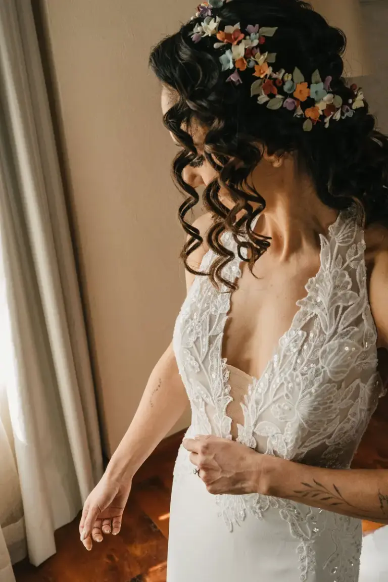 Novia con vestido de encaje en luz de ventana durante los preparativos