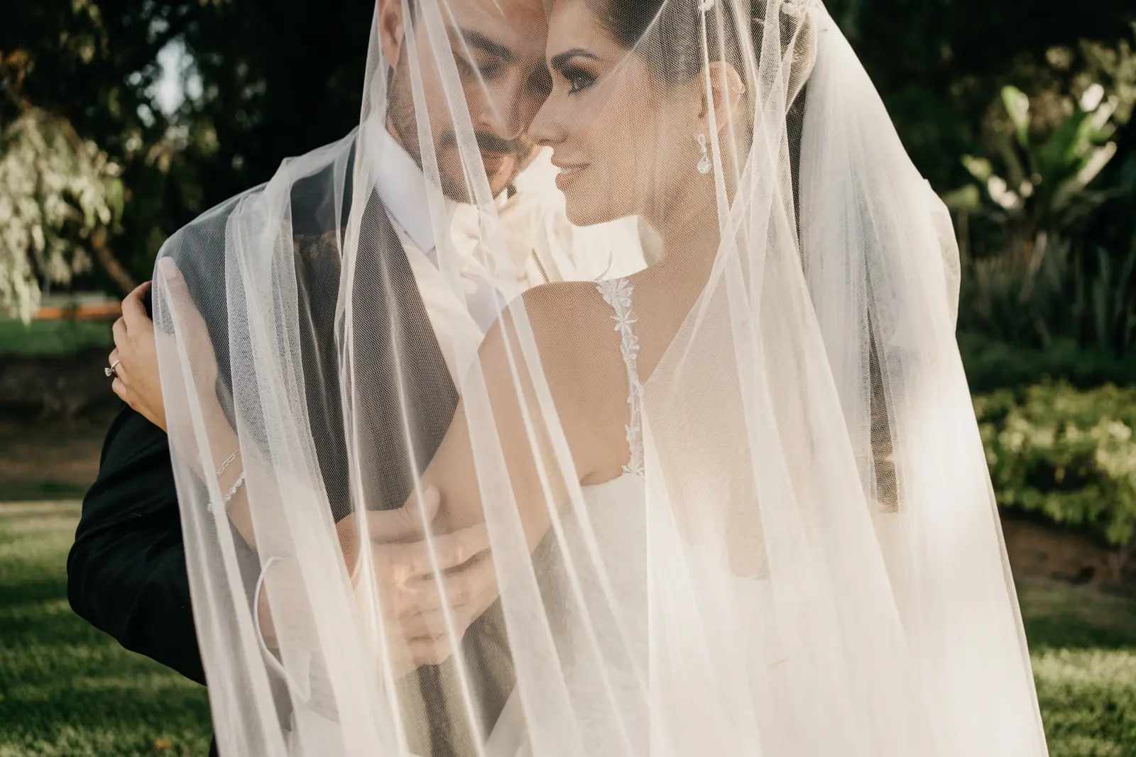 Newlyweds embracing under the veil