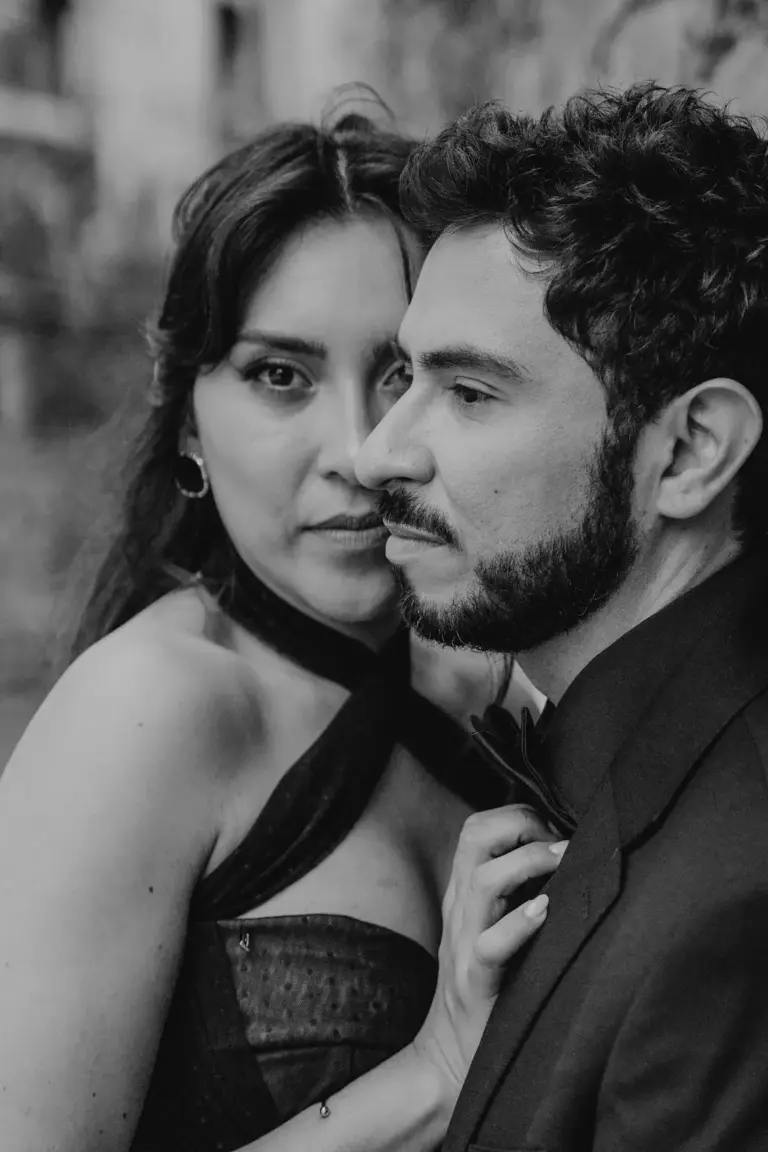 Retrato editorial intenso en blanco y negro, ella acercando a su pareja por la corbata, en Guanajuato