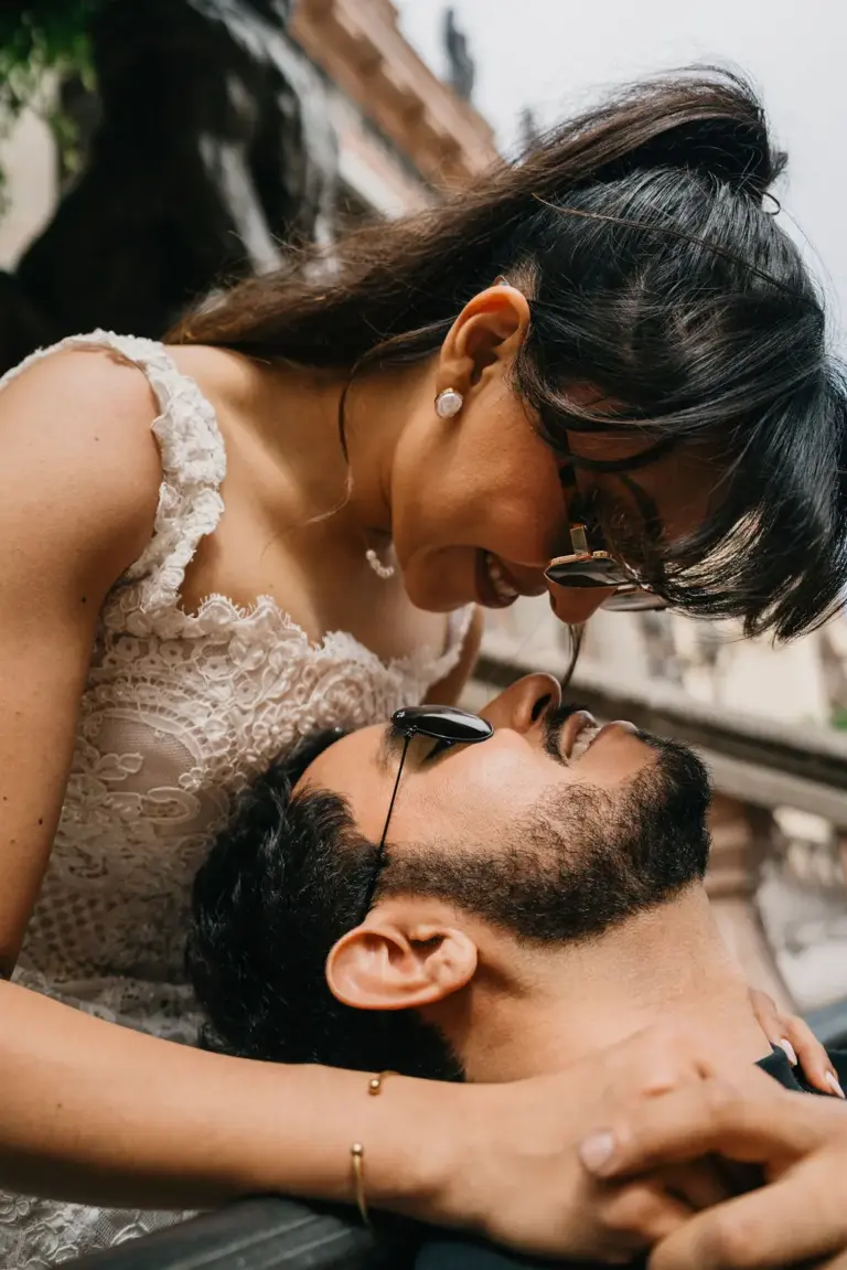 Ella recostándose para un beso sobre el barandal ornamentado del Teatro Juárez, en Guanajuato