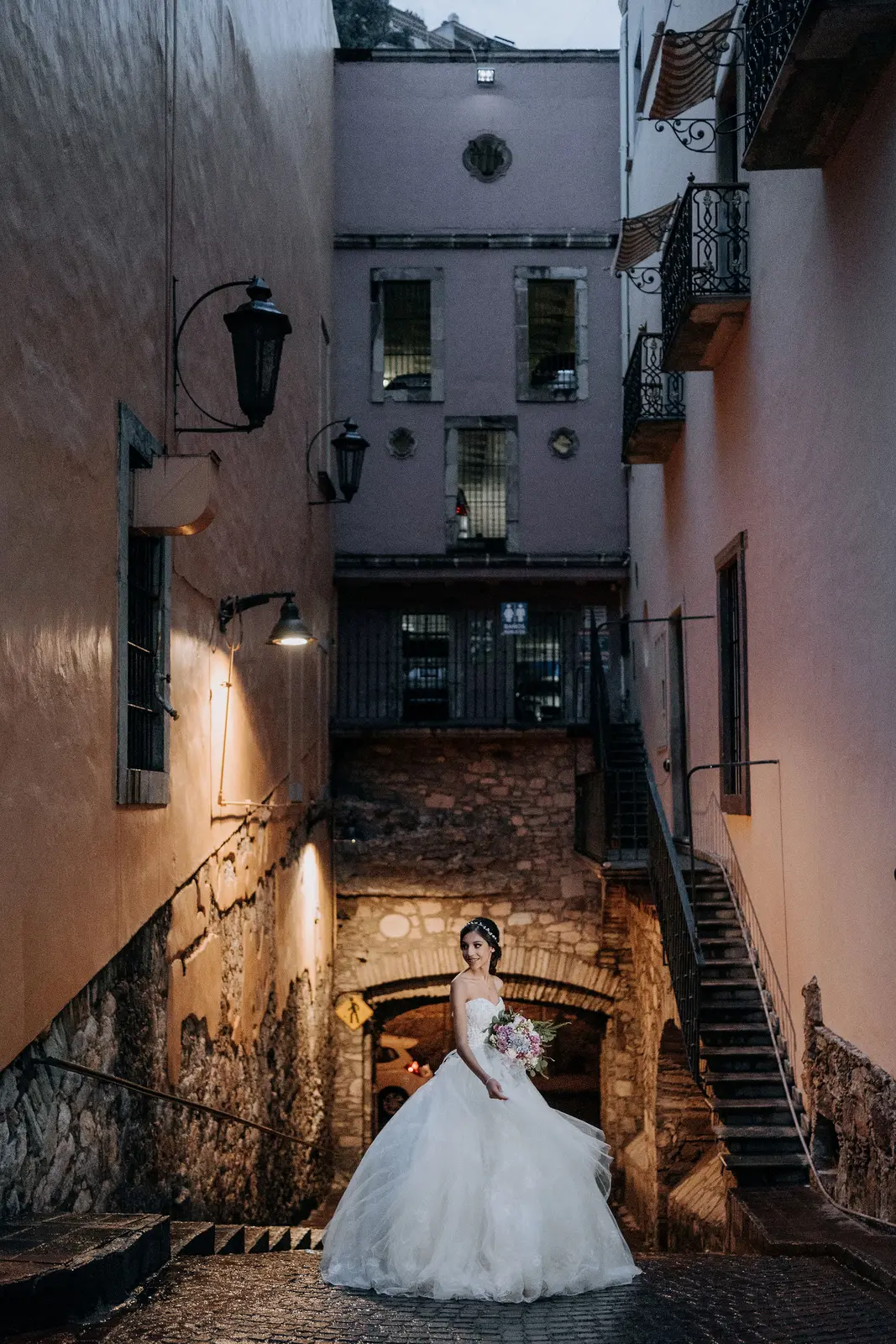 Quinceañera caminando por un callejón de Guanajuato de noche