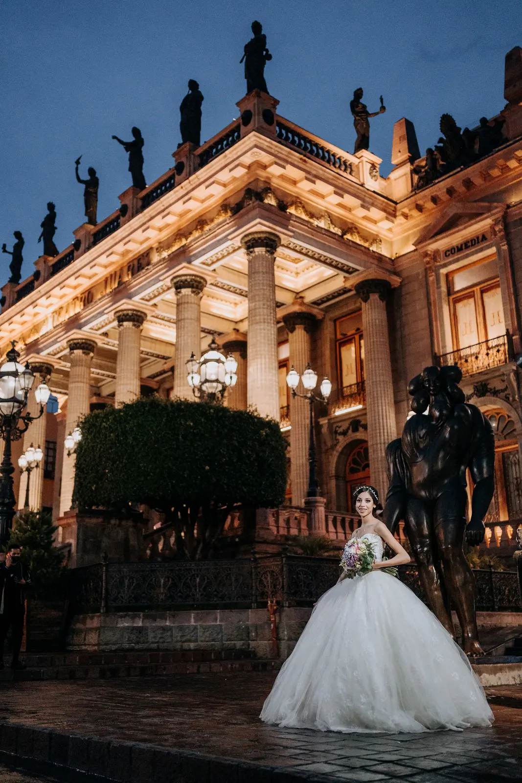 Quinceañera de noche frente al Teatro Juárez iluminado