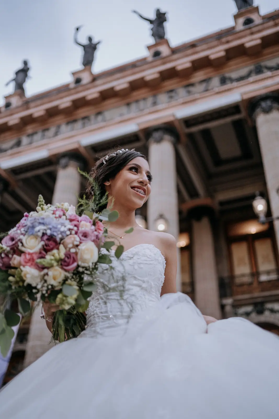 Quinceañera con su ramo frente al Teatro Juárez